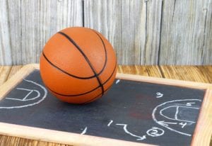 An orange basketball and a play diagram good for March madness, championship or basketball season on wooden background